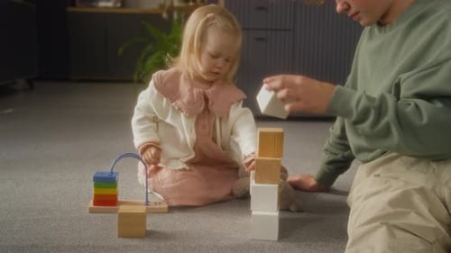 Toddler and Teen Building Blocks Together at Home