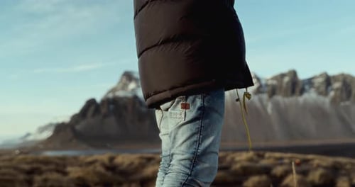 Man Wearing Black Jacket Looking Around On A Beach