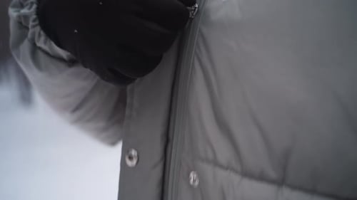 Woman Zipping Up Winter Coat in Snowy Forest