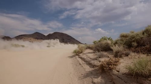Slow-Motion dust from a car/truck on dirt desert road