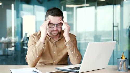 Man Working At Computer With Headache