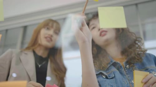 Creative Young Adults Brainstorming in Office with Sticky Notes