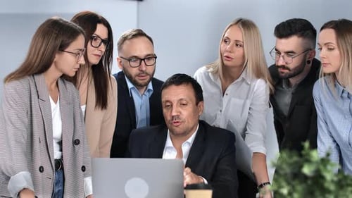 Business Team Gathers Around Laptop Discussing Project