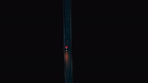 Night Drive on a Deserted Highway with Glowing Tail Lights Ahead