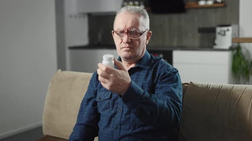 Senior Man Reads Medicine Bottle Label