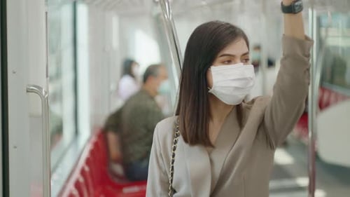 A young woman is wearing protective mask in metro