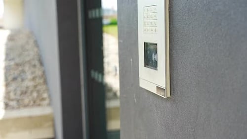Personne utilisant un porte-clés sans contact sur le système de contrôle d'accès à un bâtiment résidentiel et entrant dans