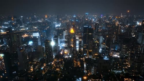 Aerial view of a vibrant city skyline at night with sparkling lights