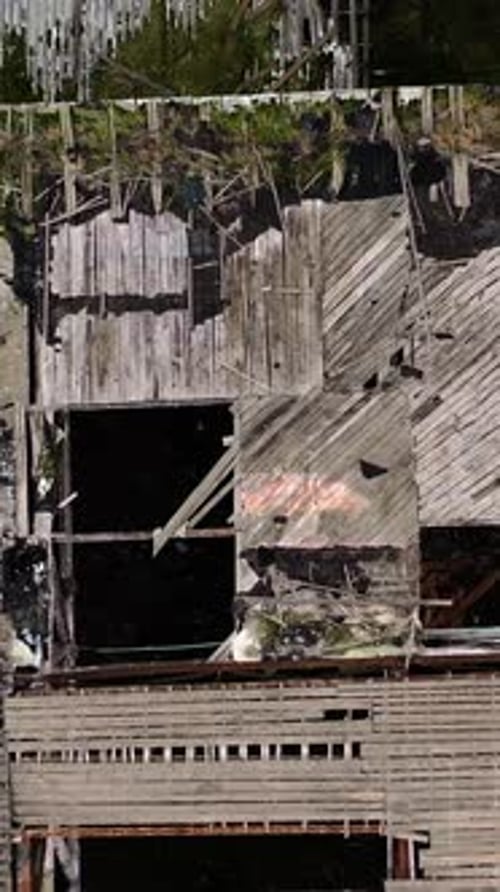 Damaged roof of a building during military action. Abandoned building with many holes outdoors.
