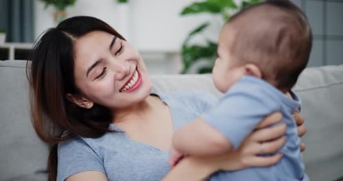 Loving Mother Holding Infant Child at Home