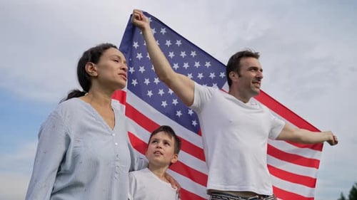 Mixed Race Family Happily Poses with American Flag