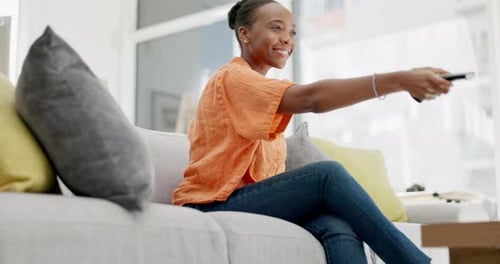 Woman Laughing while Watching Television in Living Room