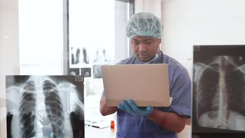 Doctor Analyzes X-Ray Using Laptop in Hospital
