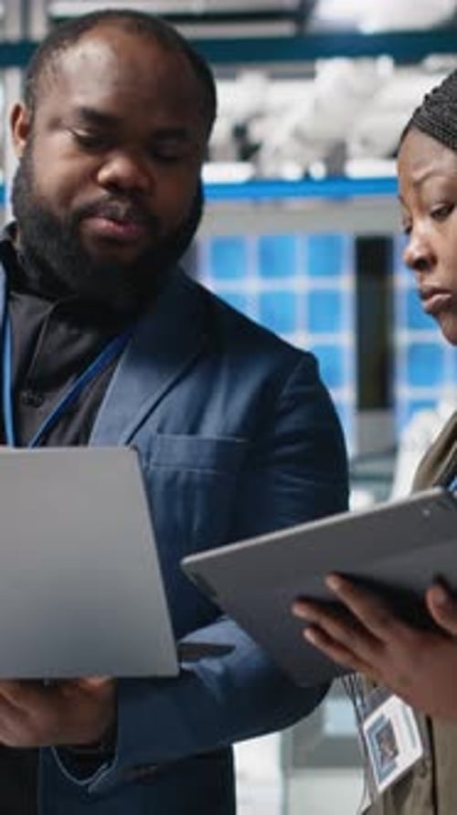 IT Professionals Reviewing Data in Modern Server Room
