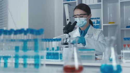Woman Scientist Working with Microscope in Lab