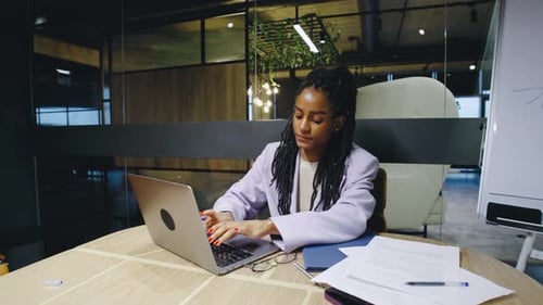 In a Contemporary Office a Dedicated Woman Focuses Intently on Her Laptop Showcasing Her Commitment