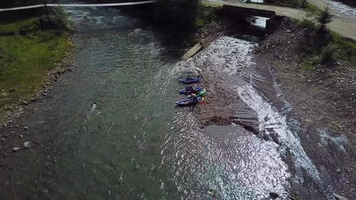 Vier Sportler beginnen mit dem River-Rafting auf Kajaks