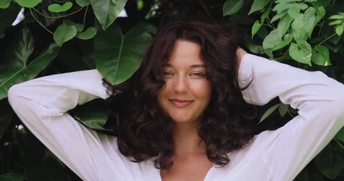 Woman Smiling near Lush Green Foliage