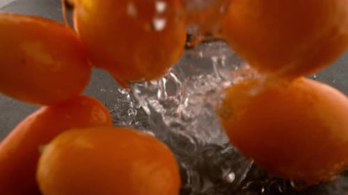Kumquat Falling Onto Wet Surface in . with Phantom Flex