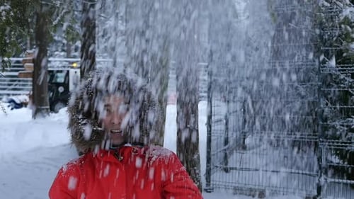 Glückliche junge Frau, die Spaß im verschneiten Wald hat
