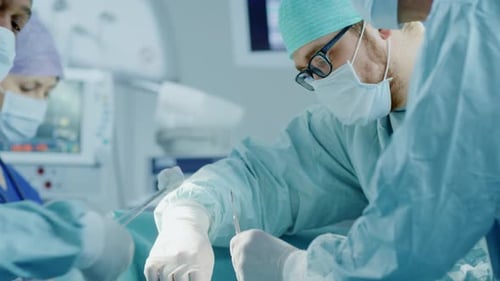 Diverse Team of Professional Surgeons Performing Invasive Surgery on a Patient in the Hospital Oper