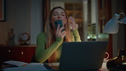 Late Worker Talking Cellphone Sitting at Remote Workplace with Laptop Close Up