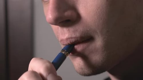 Close-up of Adult Vaping Indoors Close-up of Adult Vaping Indoors