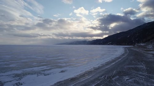 Drone Move Directly Over the Frozen Lake Baikal to Sunset