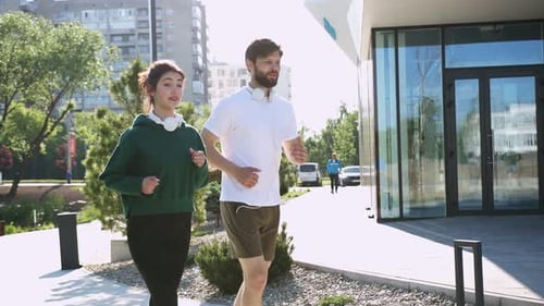 Couple Jogging Together in Urban Park on Sunny Day