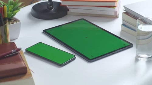 Close up of a mock up green screen chromakey tablet on neon desk. Gaming concept