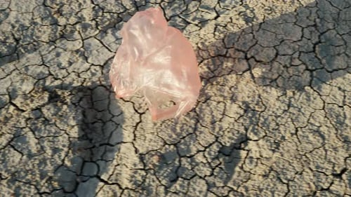 Una bolsa de plástico vuela en tierra seca: desastre ambiental