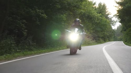 Biker Riding on Modern Sport Motorbike at Rural Forest Road Motorcyclist Racing His Motorcycle on
