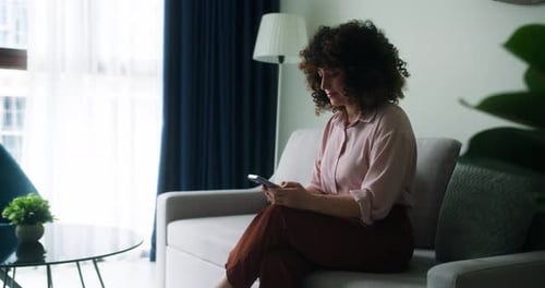 A Woman Typing on Mobile Phone Screen and Chatting in Living Room Woman's Hands Using Text Messages
