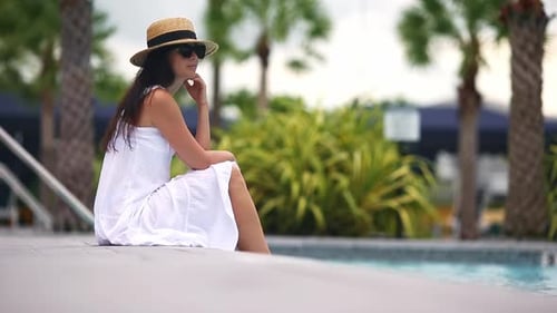 Young Beautiful Woman Enjoying Summer Vacation in Infinity Luxury Swimming Pool