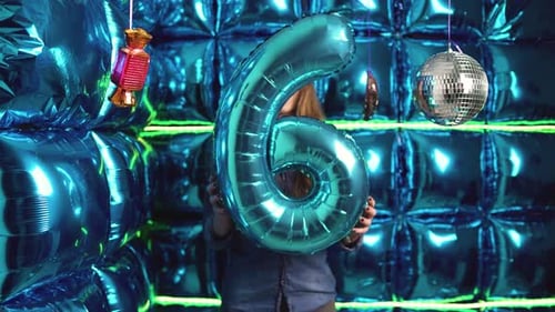 Woman Holding a Six Balloon in Party Setting