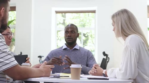Diverse Team Discussing Business in Modern Office