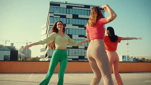 Happy Ladies Rollerblading and Dancing Energetically on Roof