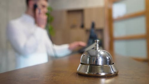 Hotel Reception Bell with Receptionist on Phone