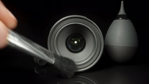 A set for cleaning lenses and photographic equipment on a black table. I take a brush and brush the