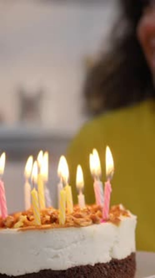 Woman Celebrates Birthday Blowing Out Candles on Cake