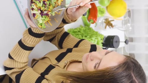Vertical Video of Eating healthy. Young woman on diet eats salad.