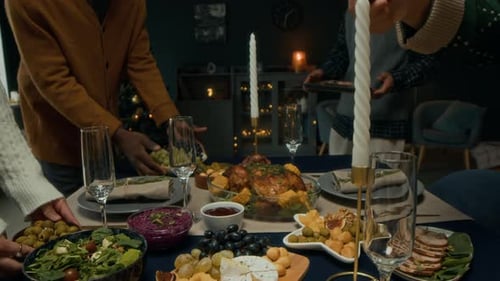 Adults Preparing a Holiday Dinner Table for Celebration