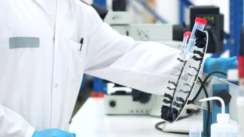 Scientist looking into a microscope sitting on a laboratory
