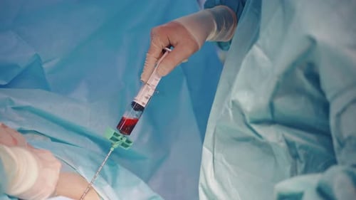 Medical Professional Using Syringe During Operation