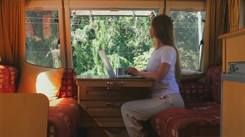Woman Using Laptop in Camper by Forest