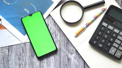 Smart Phone Financial Graph Calculator and Notepad on Table