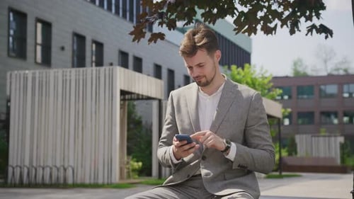 Businessman Using Smartphone in Park