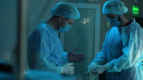 Front View of Assistant Male Helping Surgeon Putting on Latex Gloves Before Operation Portrait of