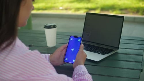 Woman Hand Holding Phone with Chroma Key Screen Outdoor Smartphone with Green Screen Closeup