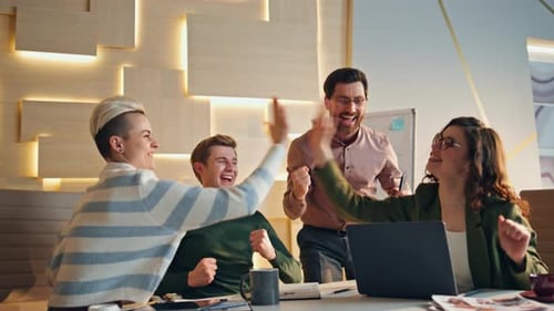 Excited Team Celebrates Business Success at Office